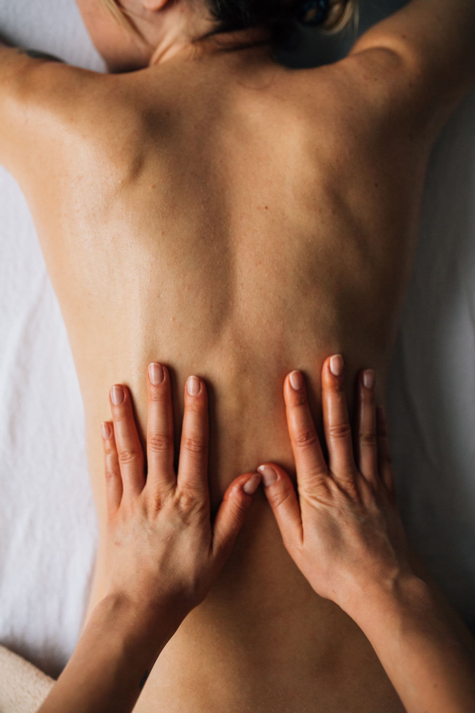 Hände bei einer wohltuenden Rückenmassage